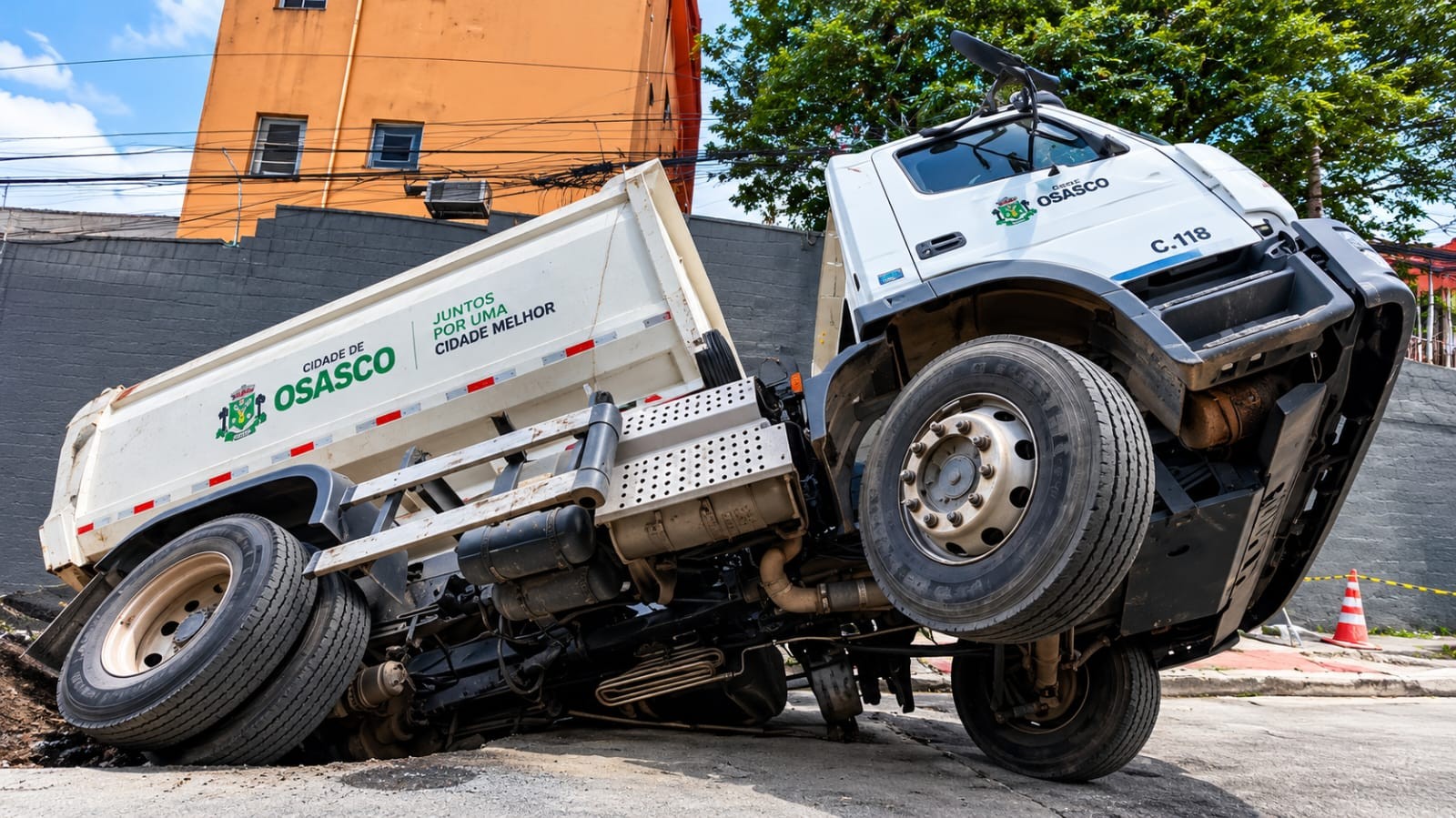 Caminhão de lixo é engolido por cratera em rua de Osasco